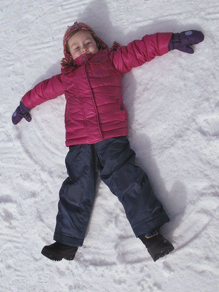 Smartphone photo of little girl doing snow angles